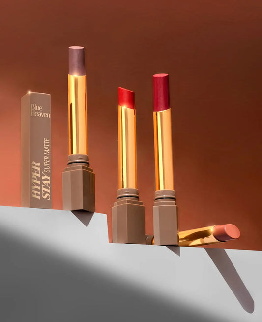 A group of three lipsticks sitting on top of a shelf