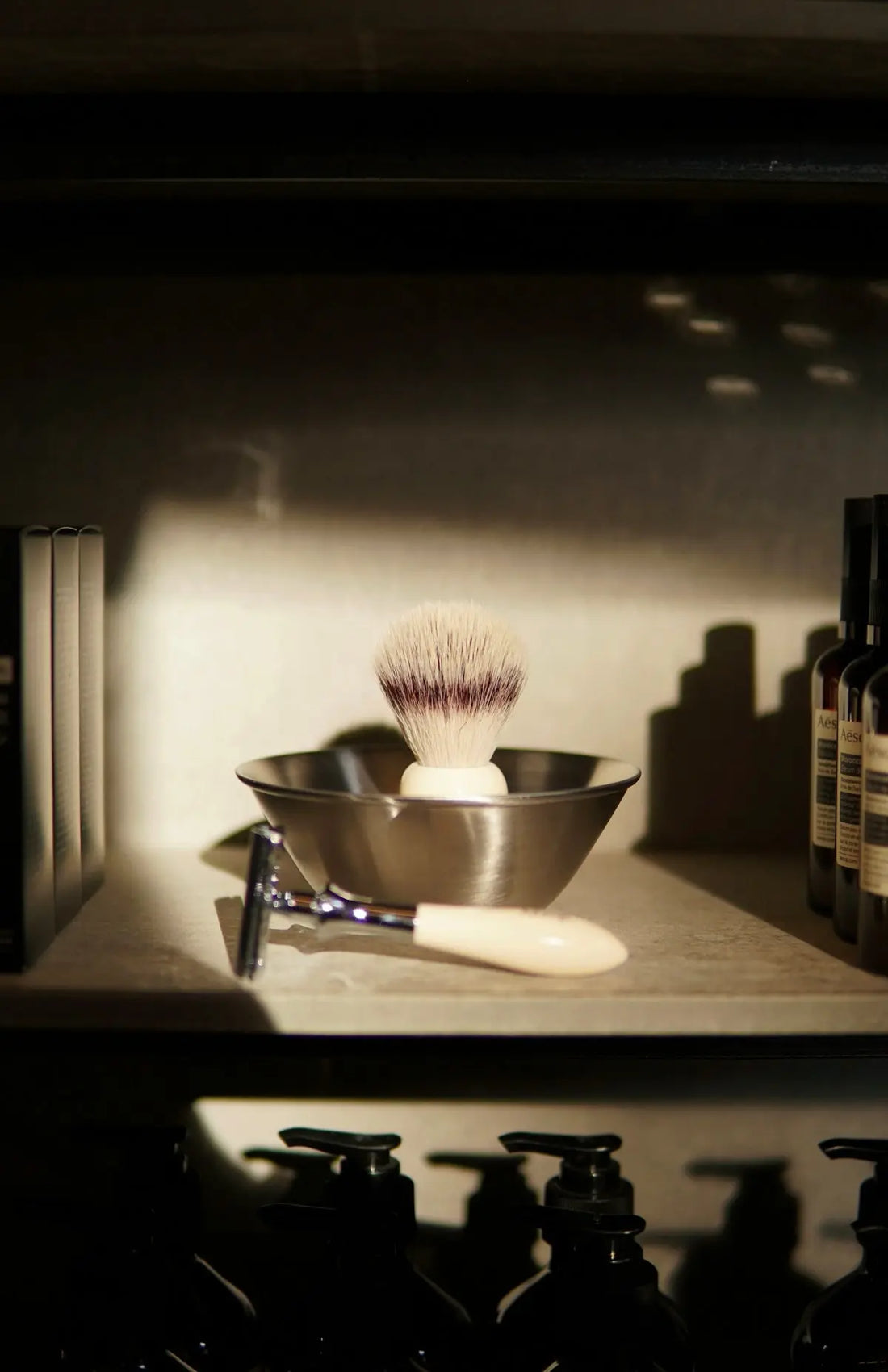 A shelf filled with bottles and a shaving brush