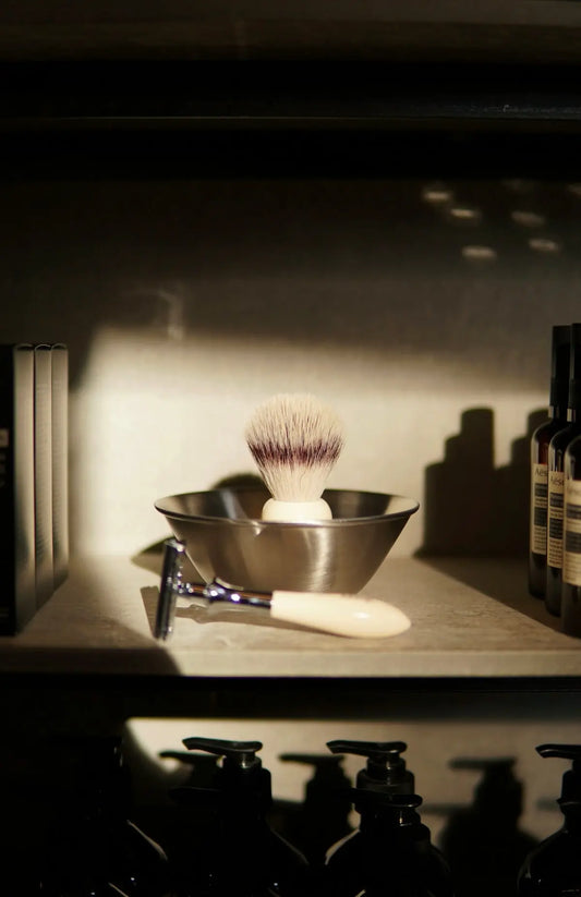 A shelf filled with bottles and a shaving brush