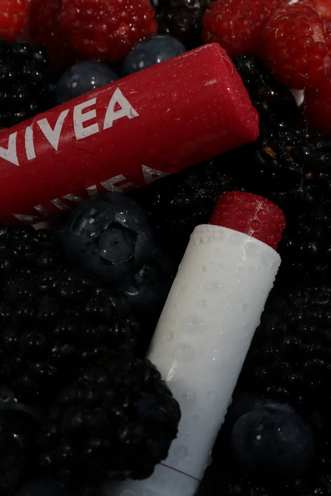 Lipsticks nestle among fresh berries.