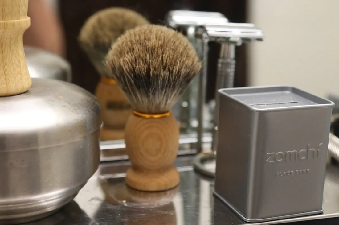 Shaving brush and razor on a reflective surface.