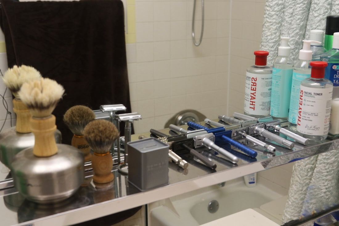 Collection of shaving brushes and razors on shelf