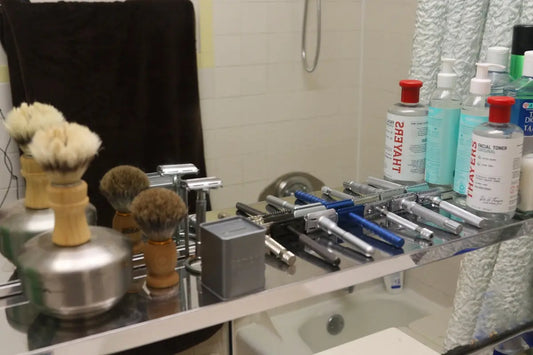 Collection of shaving brushes and razors on shelf