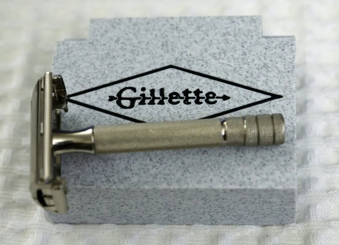 A vintage gillette safety razor rests on a grey box